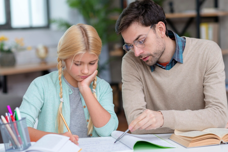 Junger Mann unterrichtet ein kleines Mädchen