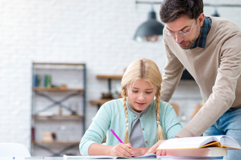 Junger Mann unterrichtet ein kleines Mädchen