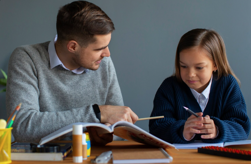 Junger Mann unterrichtet ein kleines Mädchen