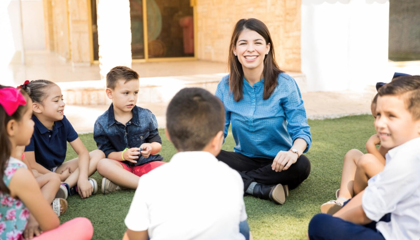 Junge Frau führt eine Gruppendiskussion mit Kindern